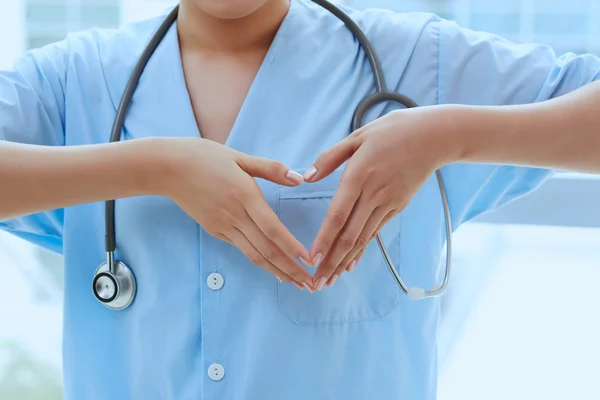 Médico mostrando forma do coração — Fotografia de Stock