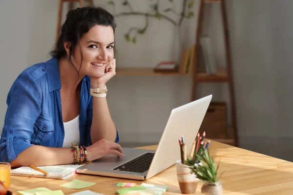 Vrouw met laptop zitten aan tafel — Stockfoto