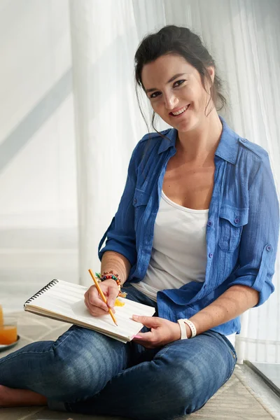 Frau zeichnet in Album — Stockfoto