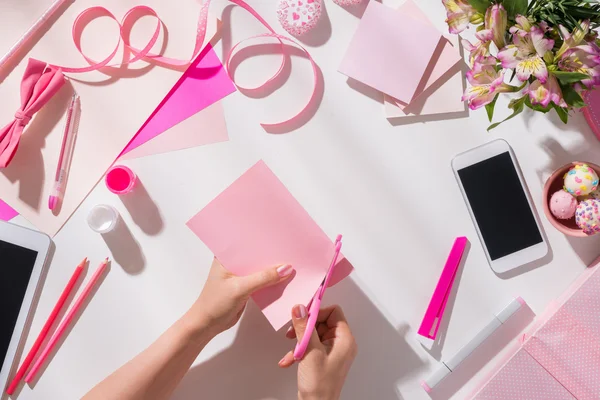 ピンク色の紙を切る女性 — ストック写真