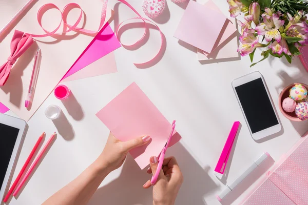 Mujer cortando papel de color rosa — Foto de Stock