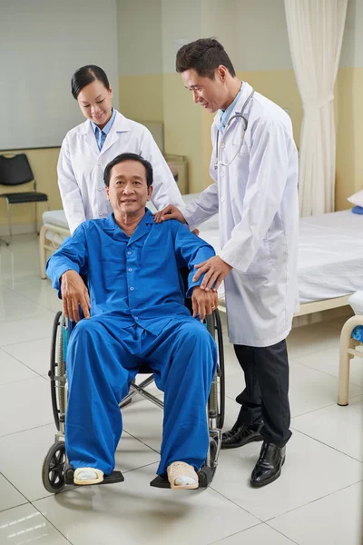 Врач успокаивает инвалида пожилого человека — стоковое фото