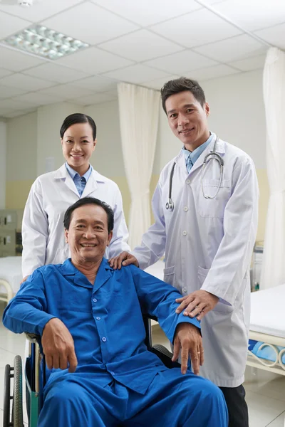 Läkare, sjuksköterska och glad mogen patienten — Stockfoto