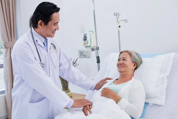 Médico tranquilizador paciente femenino — Foto de Stock