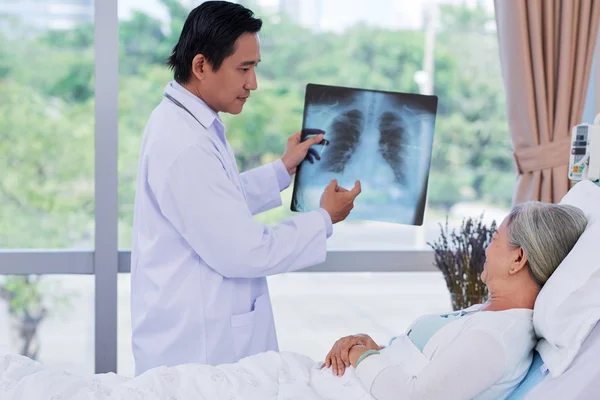 Врач показывает рентген пациенту — стоковое фото