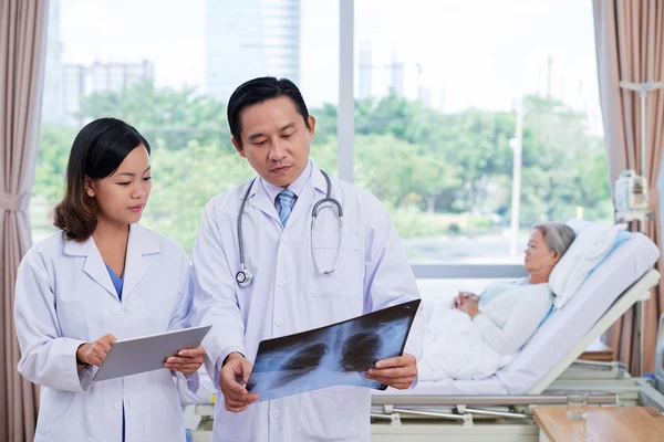 Doctor y enfermera discutiendo rayos X — Foto de Stock