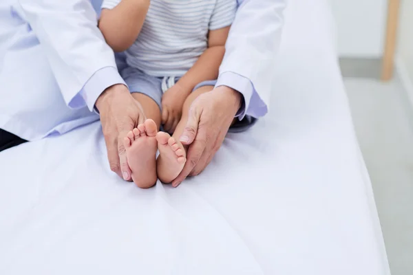 Doctor holding feet of little baby — стоковое фото