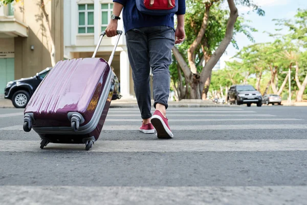 Reisende mit Koffer überquert Straße — Stockfoto