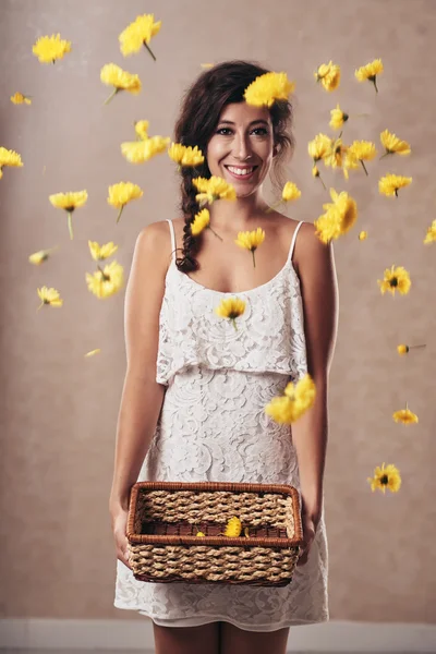 Flicka kastar korg med blommor i luften — Stockfoto