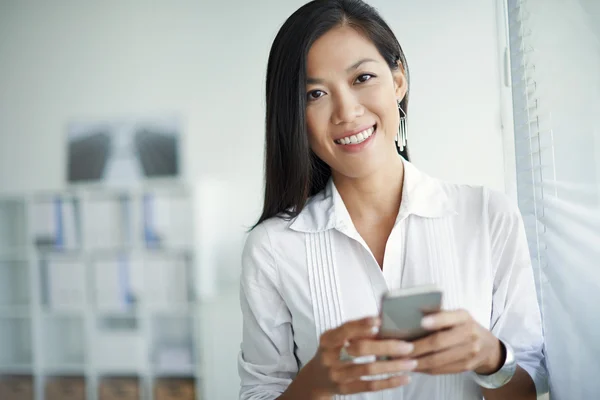 Mujer de negocios sonriente con teléfono inteligente —  Fotos de Stock