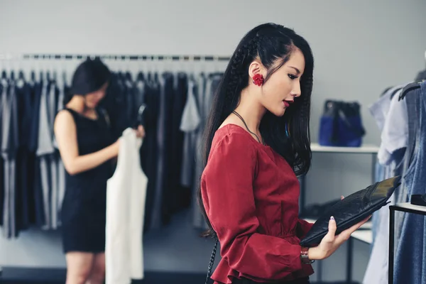 Vrouw op zoek naar lederen clutch — Stockfoto