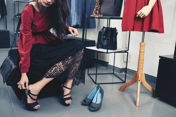 Женщина примеряет каблуки в бутике — стоковое фото