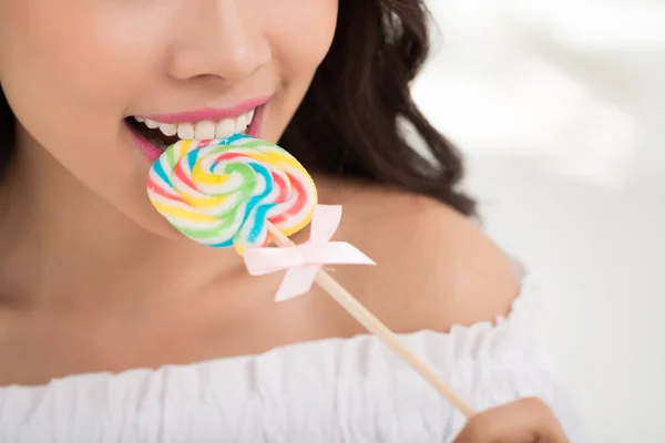 Menina comendo pirulito colorido — Fotografia de Stock