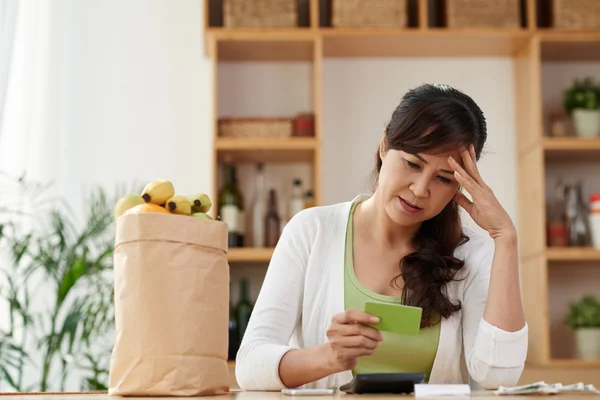 Mujer mirando la tarjeta de crédito después de comprar —  Fotos de Stock