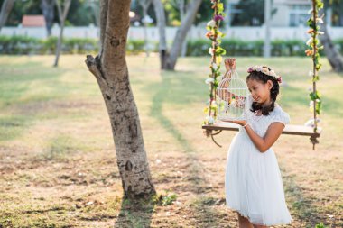 Kız holding kafes kuş ile