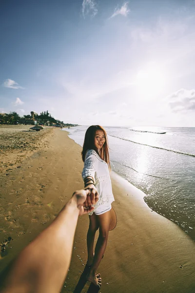 Donna sulla spiaggia tenendosi per mano del suo uomo — Foto Stock