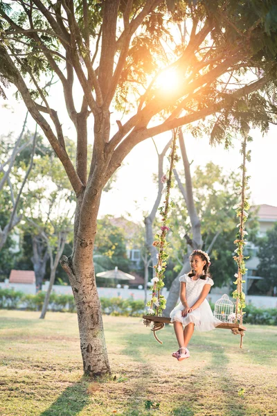 Preteen girl swinging in backyard — Stock Photo, Image