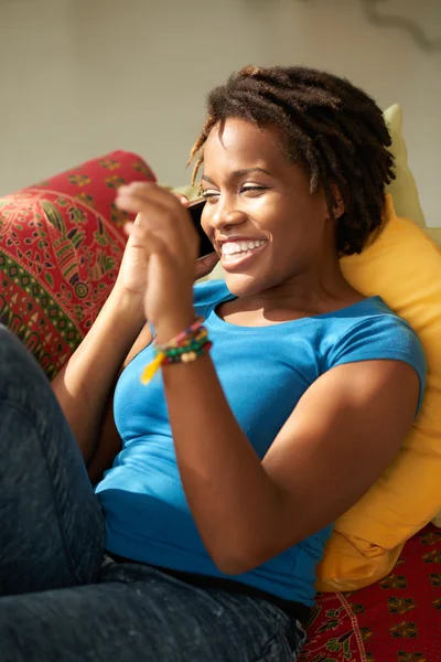 Afrikansk kvinde liggende på sofaen - Stock-foto