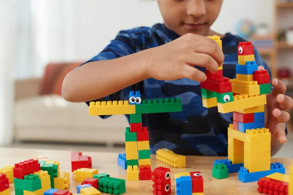 Child making creatures out of plastic bricks — Stock Photo, Image