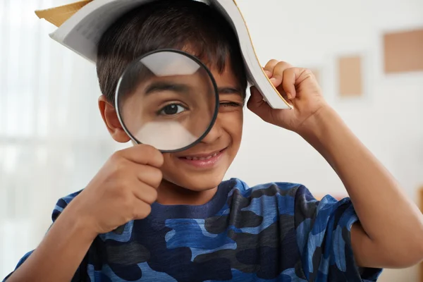 Jongen kijkt door vergrootglas — Stockfoto