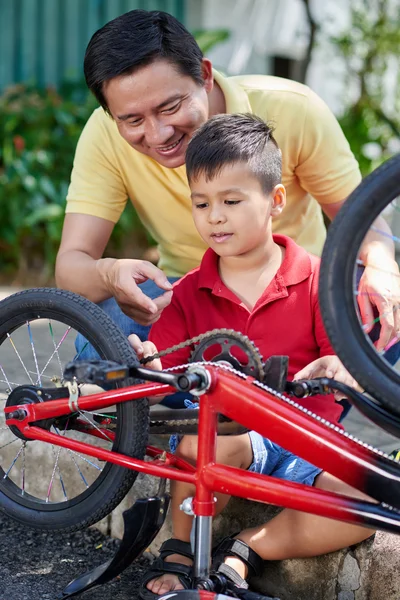 Padre e hijo reparando bicicleta — Foto de Stock