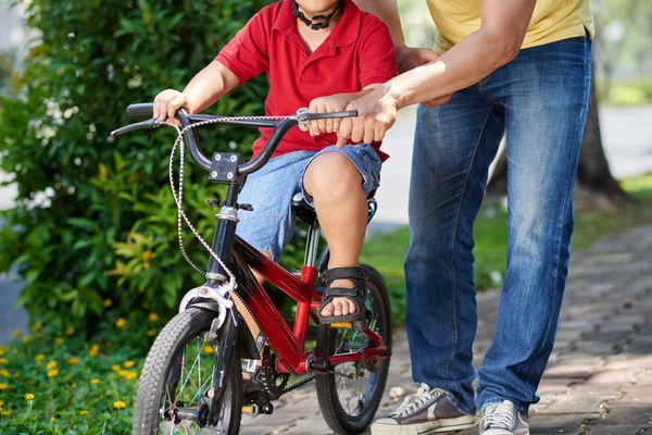 Father helping his son cycling — Stock Photo, Image