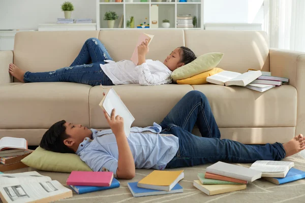 Kinder liegen auf Sofa und lesen Bücher — Stockfoto