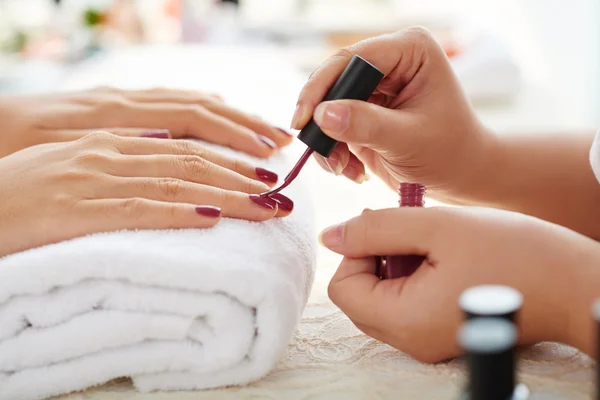 Manicura aplicando esmalte de uñas marsala —  Fotos de Stock