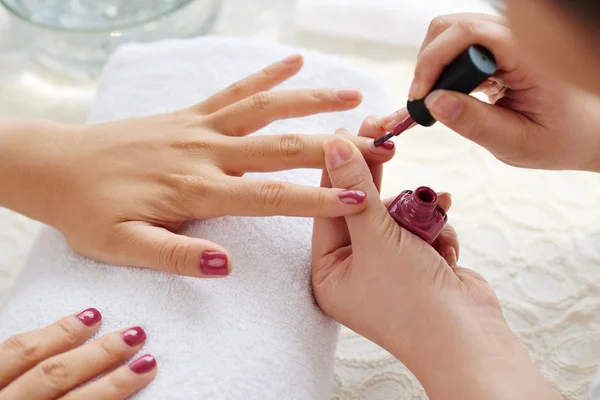 Master applying polish on fingernails Stock Picture