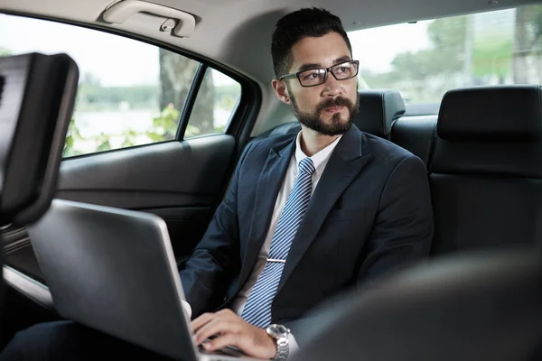 Biznesmen działa na laptopie w samochodzie — Zdjęcie stockowe
