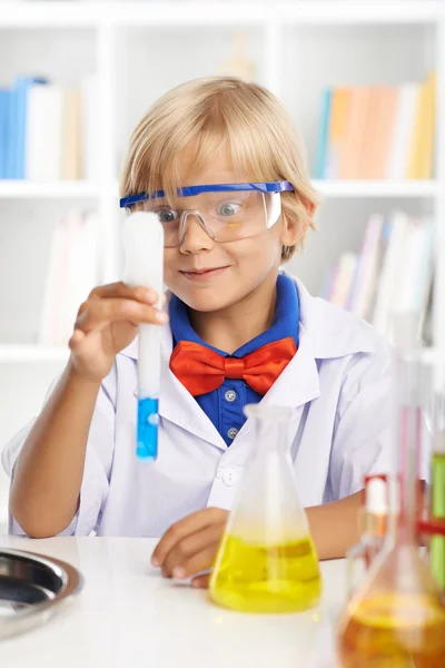 Schoolboy looking at chemical reaction — Stock Photo, Image