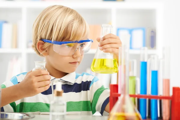 Niño con gafas sosteniendo frasco — Foto de Stock