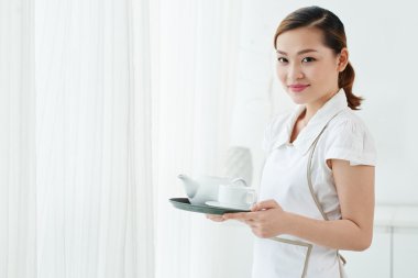 Oda hizmetçisi holding çaydanlık ve bardak 