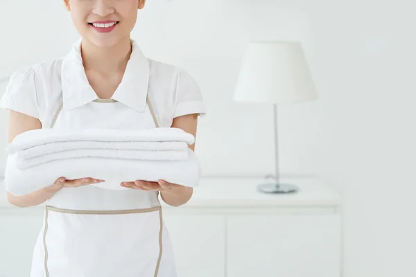 Kamermeisje met witte handdoeken in handen — Stockfoto