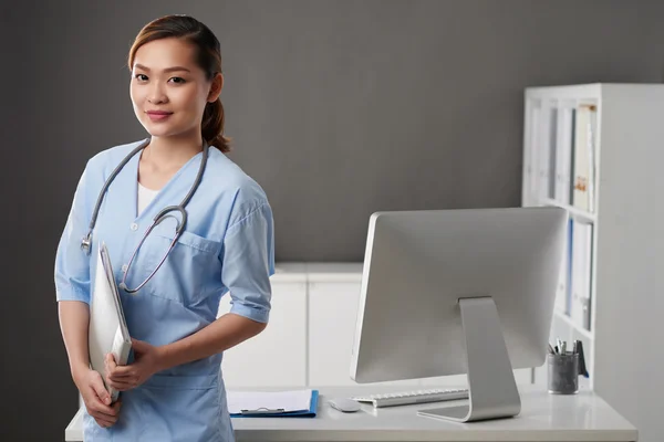 Junge Ärztin steht im Büro — Stockfoto