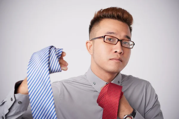 Asian businessman choosing perfect tie — Stock Photo, Image