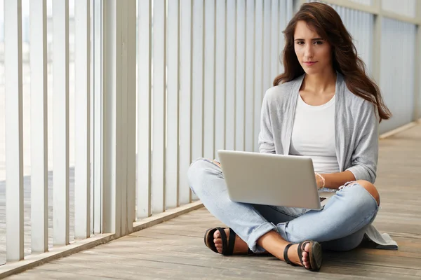 Networking meisje zittend op de vloer — Stockfoto