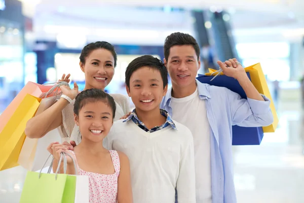 Vierköpfige Familie mit Einkaufstaschen — Stockfoto