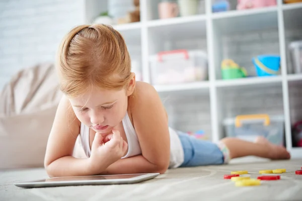 Chica acostada en el suelo y viendo dibujos animados —  Fotos de Stock