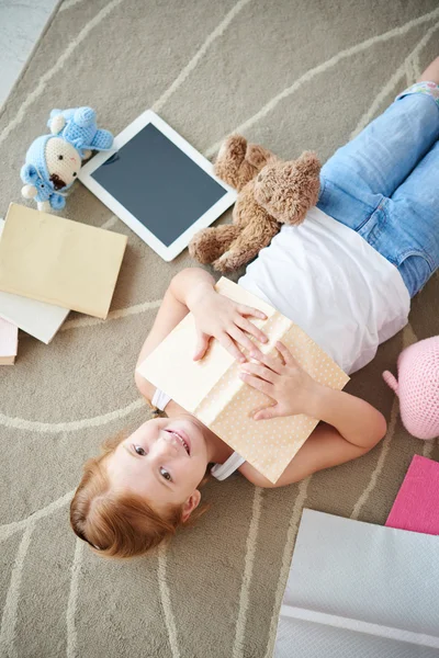 Девушка с книгами лежит на полу — стоковое фото