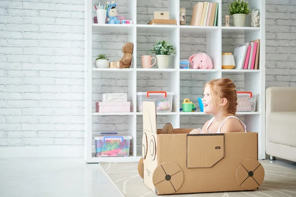 girl driving cardboard car