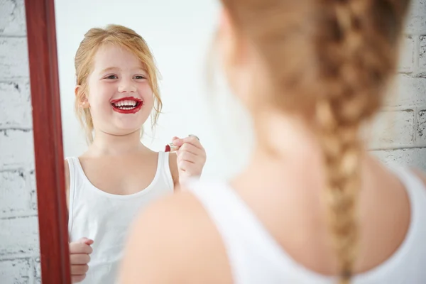 Ragazza che applica rossetto rosso — Foto Stock