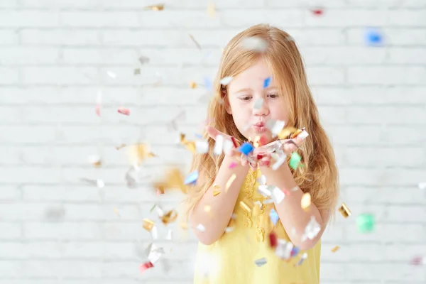 Dívka foukání bodů confetti — Stock fotografie