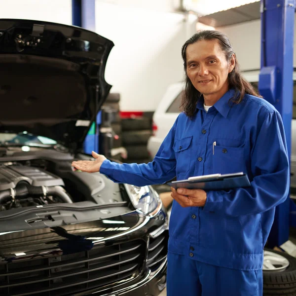 Mecánico mostrando coche reparado —  Fotos de Stock