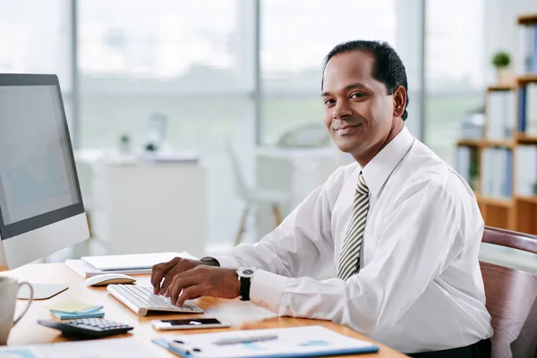 Hombre de negocios sonriente en su lugar de trabajo — Foto de Stock