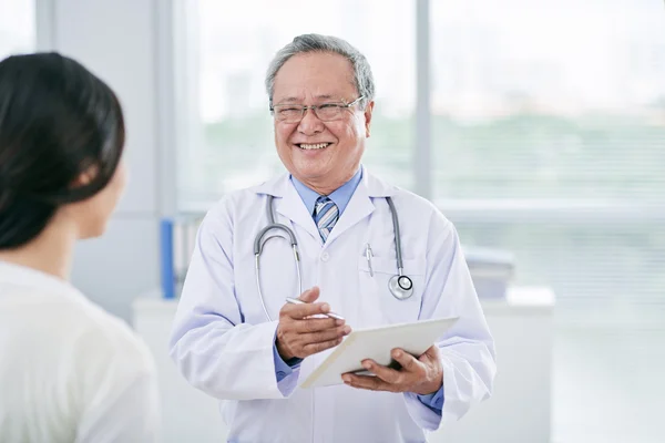 Médico consultando seu paciente feminino — Fotografia de Stock