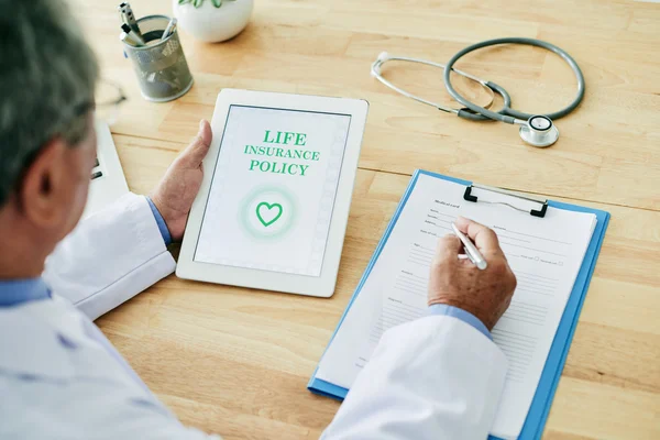 Doctor working with insurance policy — Stock Photo, Image