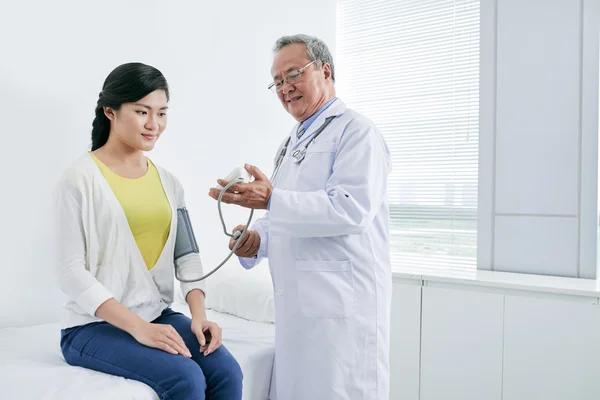 Docteur vérifiant la pression artérielle de la femme — Photo