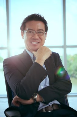 Mutlu işadamı onun sandalyede oturuyor