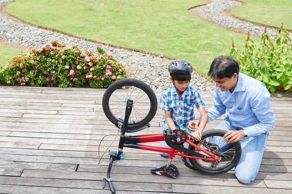 Padre e hijo reparando bicicleta — Foto de Stock